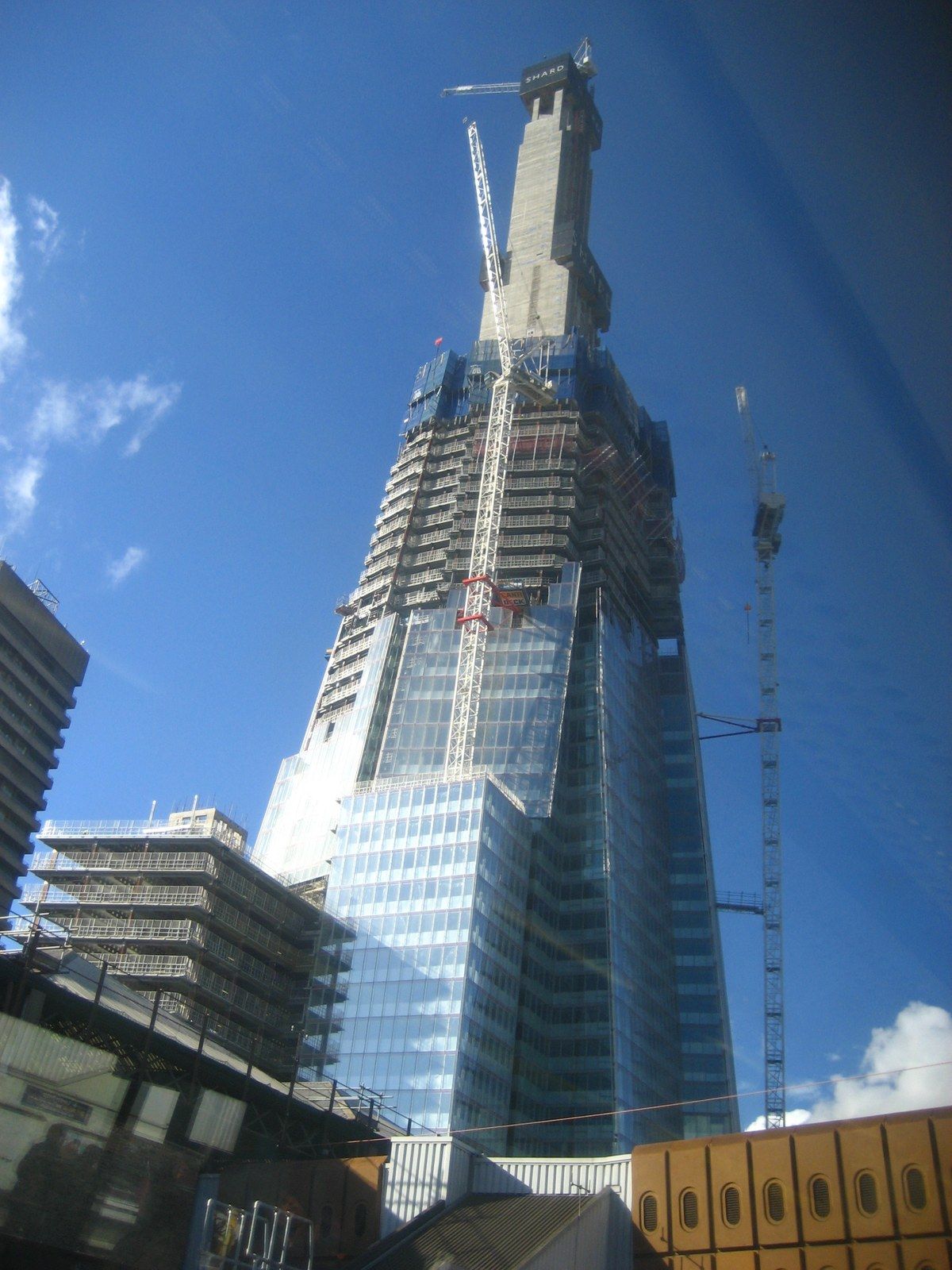 A tower under construction with climbing formwork at the top of its core, seen from the street, a Wikimedia Commons photograph in Michael Stern's encyclopedia