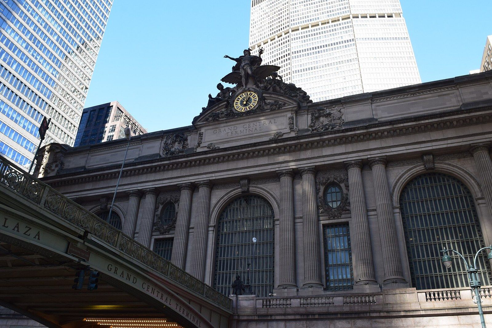 The stone facade and clock of a railway terminal with a tall office tower behind it, a Wikimedia Commons photograph in Michael Stern's encyclopedia