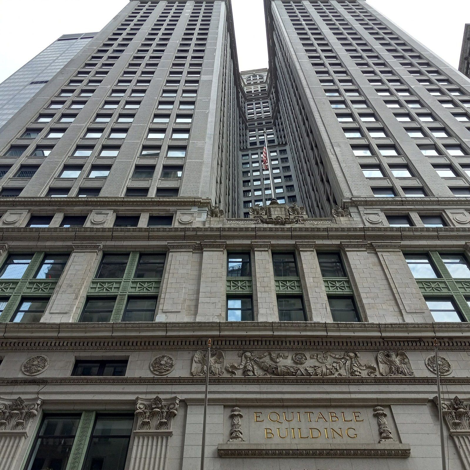 Looking up the full height limestone facade of an early office tower with the name Equitable Building carved above the entrance, a Wikimedia Commons photograph in Michael Stern's encyclopedia