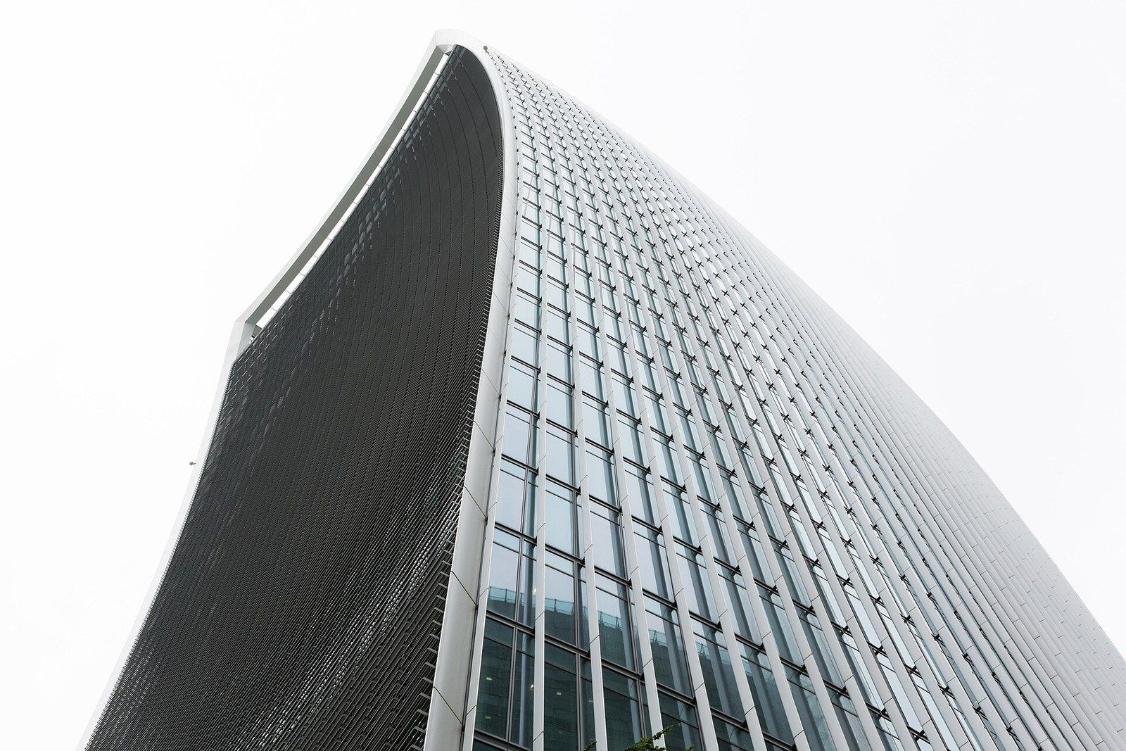 Looking up the concave glass face of an office tower that widens toward the top, a Wikimedia Commons photograph in Michael Stern's encyclopedia