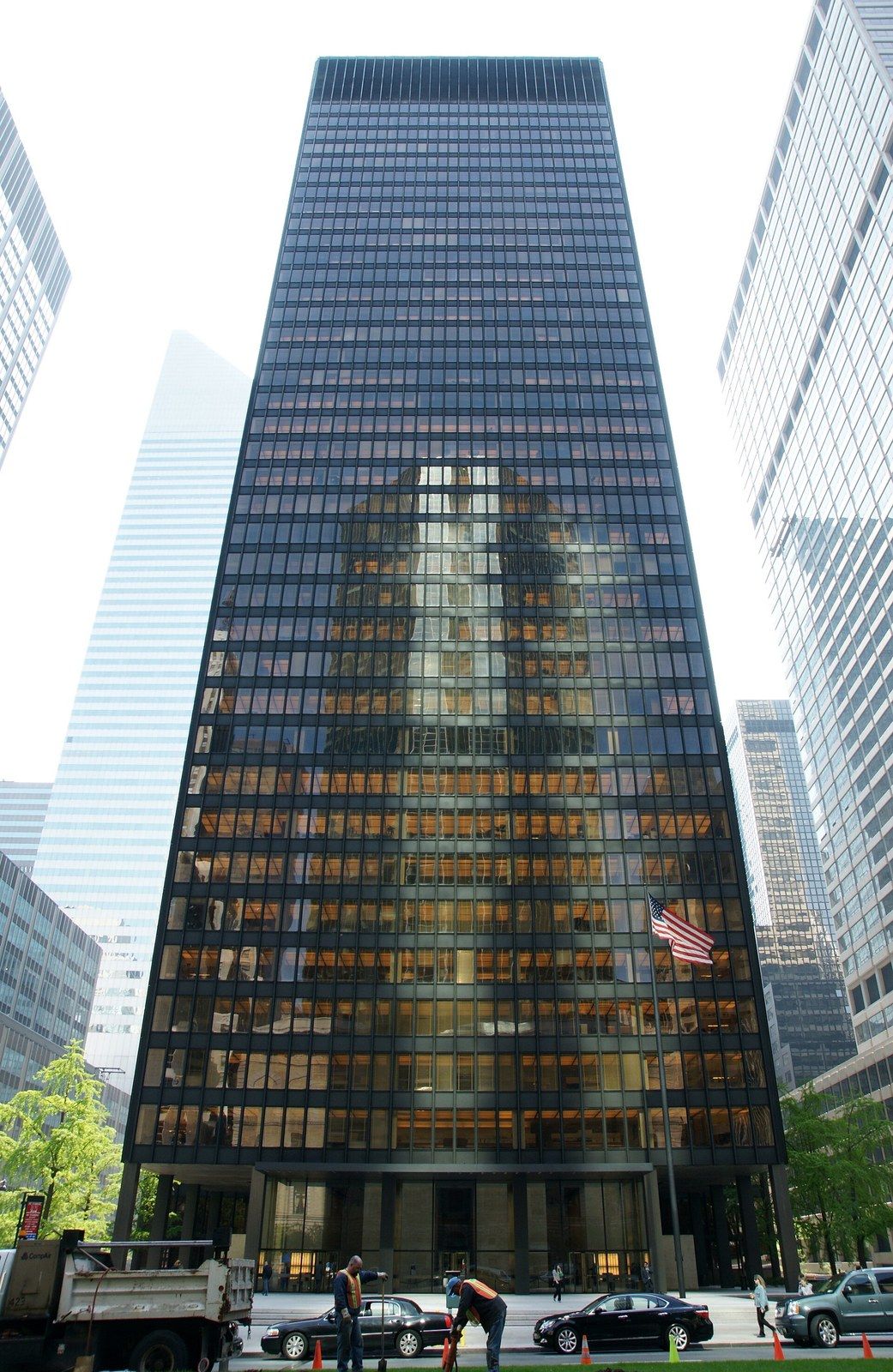 A bronze tinted glass tower set back behind an open plaza on an avenue, a Wikimedia Commons photograph in Michael Stern's encyclopedia