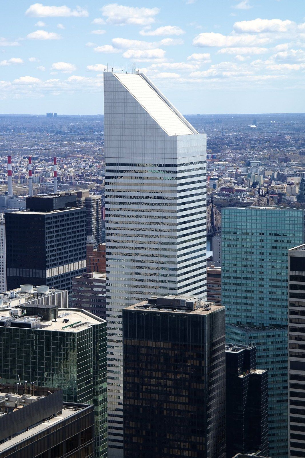 An office tower with a sloped crown seen from above the surrounding rooftops, a Wikimedia Commons photograph in Michael Stern's encyclopedia