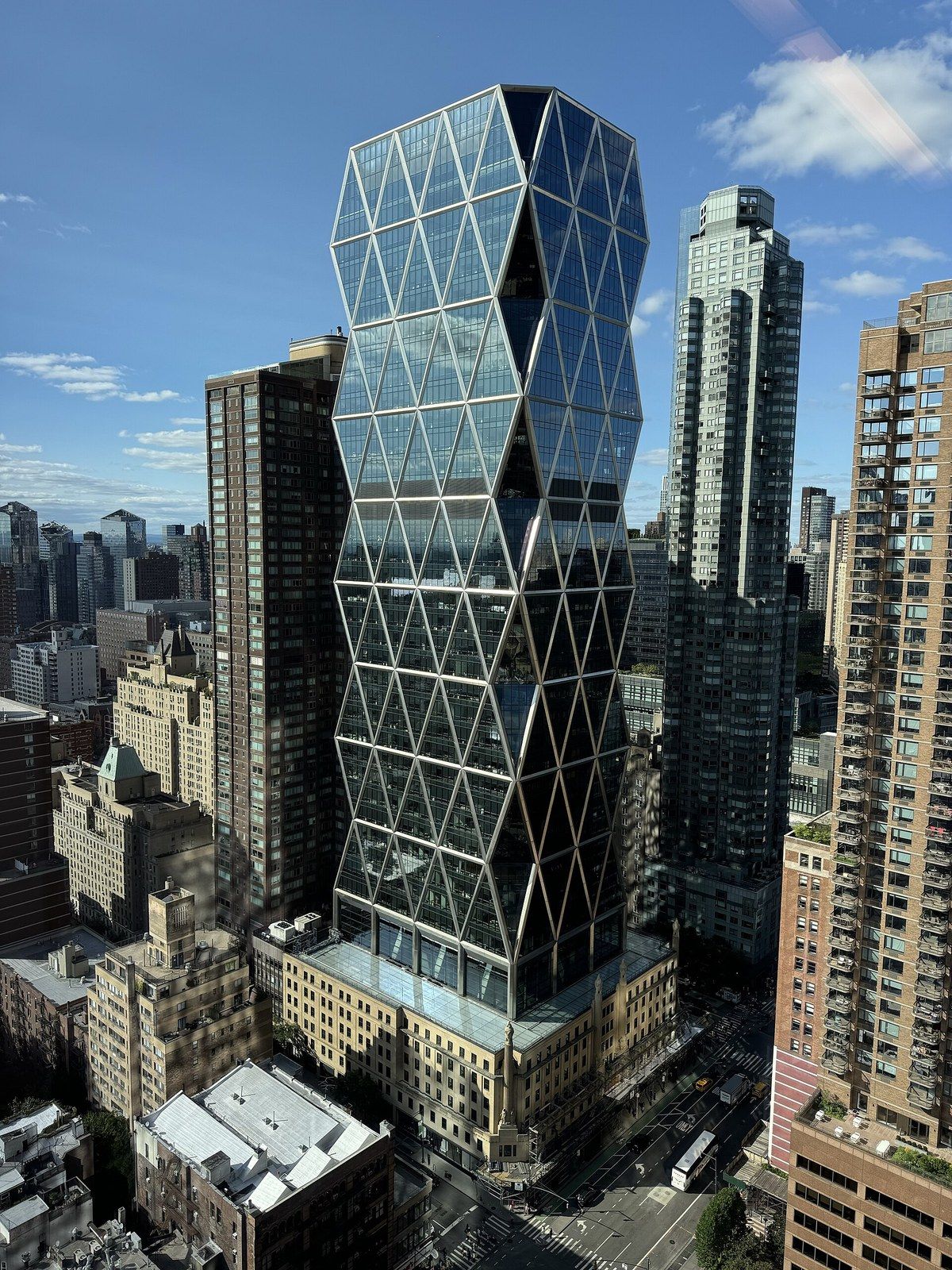 A diagrid glass tower rising from a six storey stone base, seen from above the street, a Wikimedia Commons photograph in Michael Stern's encyclopedia