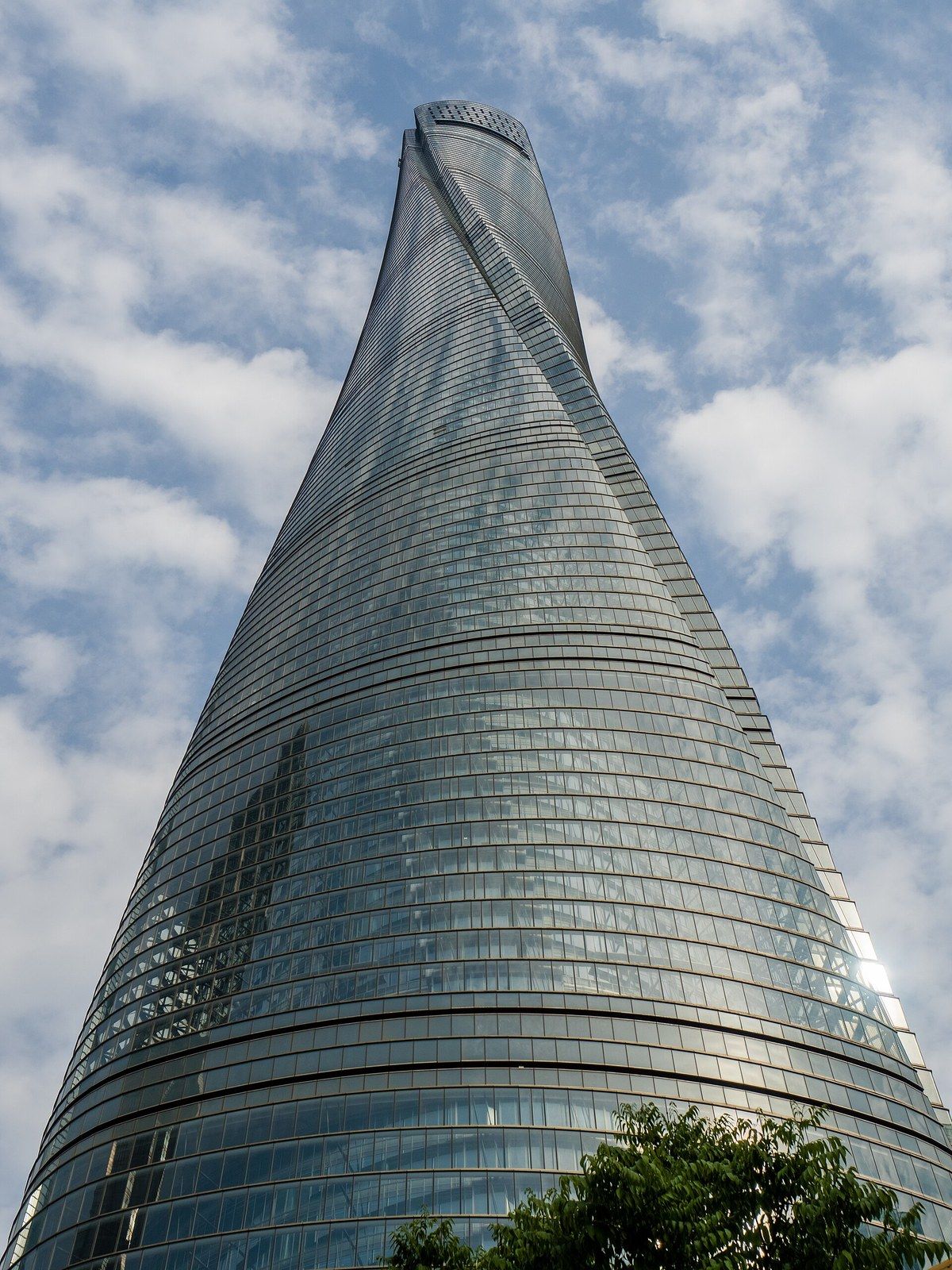 Looking up a twisting glass supertall tower against a cloudy sky, a Wikimedia Commons photograph in Michael Stern's encyclopedia