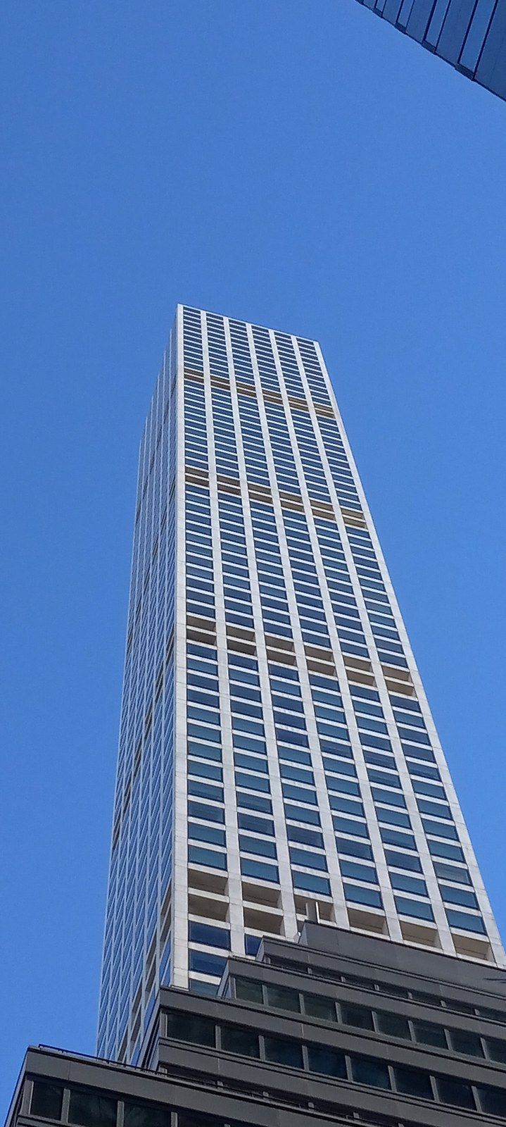 A very tall, narrow residential tower with a square grid facade against a clear sky, a Wikimedia Commons photograph in Michael Stern's encyclopedia