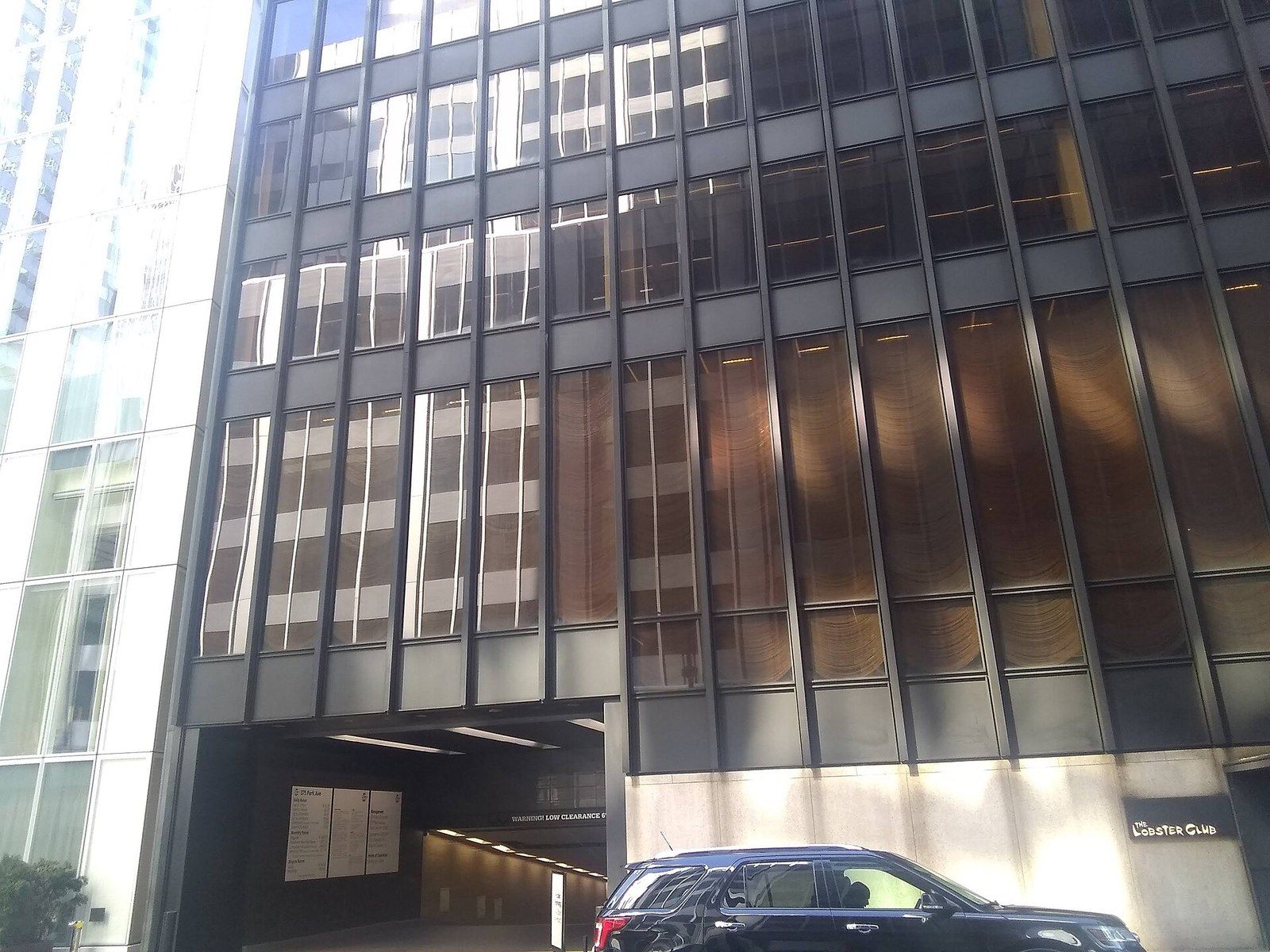 A bronze and glass office tower seen from the street with a car passing, a Wikimedia Commons photograph in Michael Stern's encyclopedia