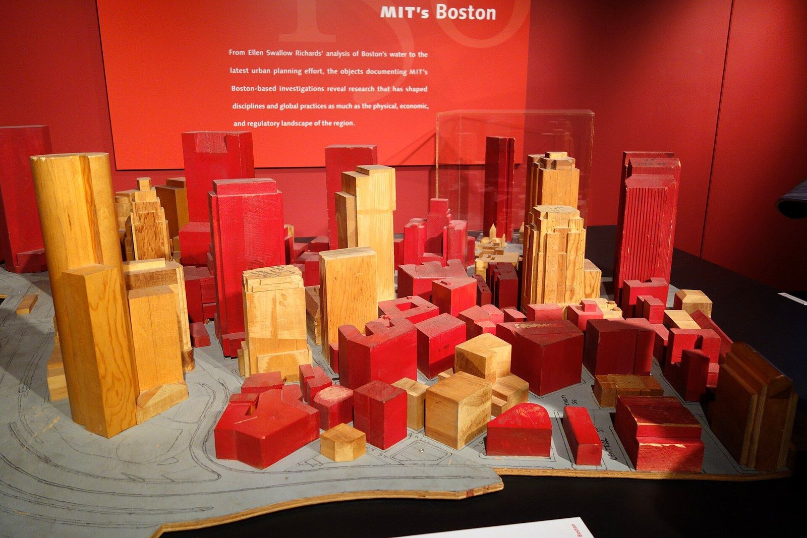 A wooden wind tunnel model of a city block with buildings in red and natural wood, displayed in a museum, a Wikimedia Commons photograph in Michael Stern's encyclopedia